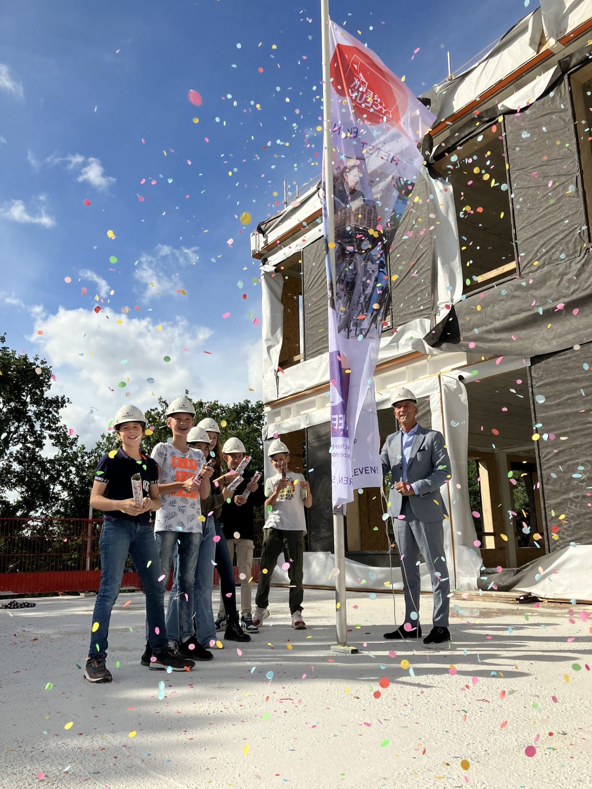 Nieuwe rector en brugklasleerlingen hijsen vlag voor hoogste punt nieuwbouw Het Streek Lyceum